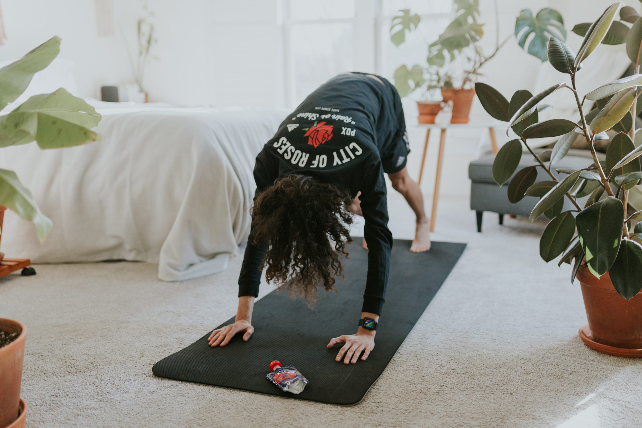 woman in her bedroom on a yoga mat doing a home workout routine